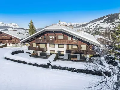 a large house in the snow with snow at Studio skis aux pieds à Megève, animaux permis - FR-1-453-58 in Megève