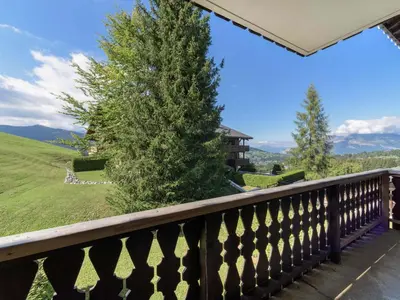 a balcony with a view of a tree and mountains at Studio skis aux pieds à Megève, animaux permis - FR-1-453-58 in Megève