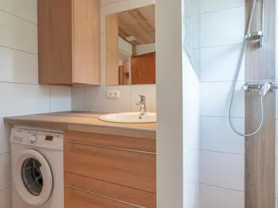 a bathroom with a sink and a washing machine at Appartement cosy à Megève, 1 chambre, parking, wifi - FR-1-453-59 in Megève