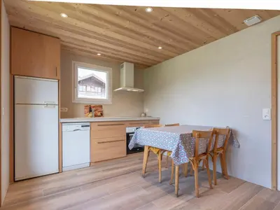 a kitchen with a table with chairs and a refrigerator at Appartement cosy à Megève, 1 chambre, parking, wifi - FR-1-453-59 in Megève