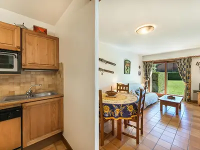 a kitchen with a table and a room with a bed at Appartement 1 Chambre Confort à Megève - Animaux Bienvenus - FR-1-453-61 in Megève
