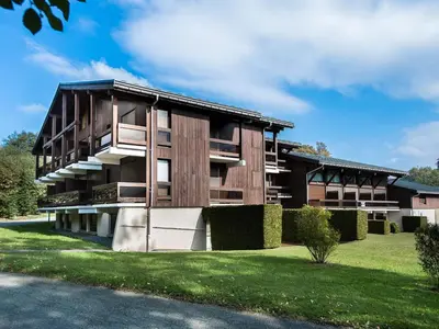 an apartment building with a green lawn in front of it at Appartement 1 Chambre Confort à Megève - Animaux Bienvenus - FR-1-453-61 in Megève