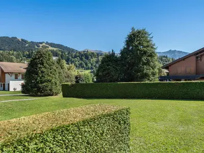 a hedge in a yard with a house and trees at Appartement 1 Chambre Confort à Megève - Animaux Bienvenus - FR-1-453-61 in Megève