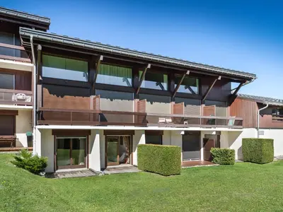 an exterior view of a building with green grass at Appartement 1 Chambre Confort à Megève - Animaux Bienvenus - FR-1-453-61 in Megève