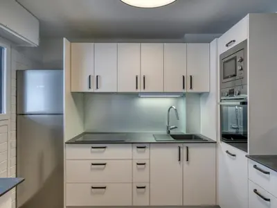 a kitchen with white cabinets and a sink and a refrigerator at Appartement spacieux 1 chambre à Megève, balcon, parking inclus - FR-1-453-62 in Megève
