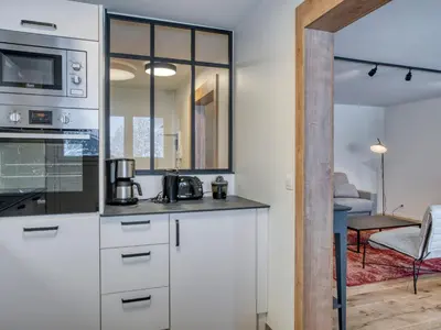 a kitchen with white cabinets and a microwave at Appartement spacieux 1 chambre à Megève, balcon, parking inclus - FR-1-453-62 in Megève