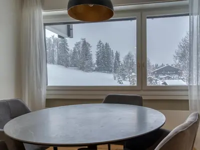 a table and chairs in a room with a large window at Appartement spacieux 1 chambre à Megève, balcon, parking inclus - FR-1-453-62 in Megève