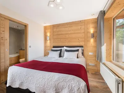 a bedroom with a large bed with wooden walls at Appartement rénové 2 chambres à Megève Centre avec balcon - FR-1-453-66 in Megève