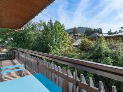 a patio with a table and chairs on a deck at Appartement rénové 2 chambres à Megève Centre avec balcon - FR-1-453-66 in Megève