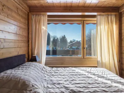 a bedroom with a bed and a large window at Spacieux T2 rénové avec Parking et WiFi à Megève, Proche Pistes - FR-1-453-68 in Megève
