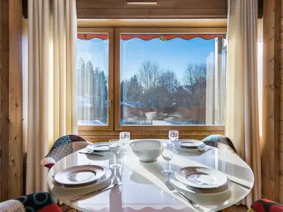 a white table with plates and wine glasses in front of a window at Spacieux T2 rénové avec Parking et WiFi à Megève, Proche Pistes - FR-1-453-68 in Megève