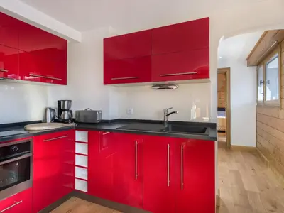 a kitchen with red cabinets and a sink at Spacieux T2 rénové avec Parking et WiFi à Megève, Proche Pistes - FR-1-453-68 in Megève