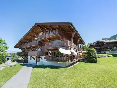 a large wooden house with balconies on a lawn at Appartement 3 pièces, 4 pers, Megève Mont d'Arbois, TV, Wifi - FR-1-453-76 in Megève