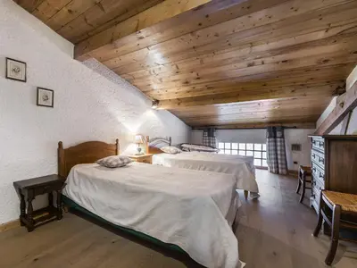 two beds in a large room with wooden ceilings at Appartement 2 chambres au centre de Megève avec WiFi - FR-1-453-78 in Megève