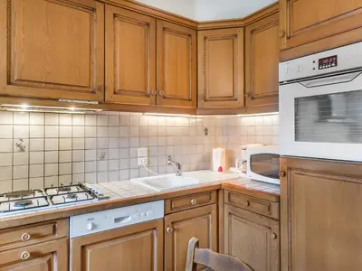 a kitchen with wooden cabinets and a sink and a microwave at Appartement 3 pièces avec balcon et wifi - Megeve Jaillet - FR-1-453-80 in Megève