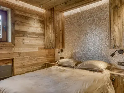 a bedroom with wooden walls and a bed with two pillows at Charmant 2 pièces proche pistes à Megève - FR-1-453-83 in Megève