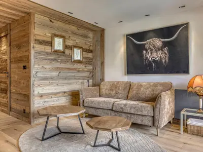 a living room with a couch and a bull on the wall at Charmant 2 pièces proche pistes à Megève - FR-1-453-83 in Megève