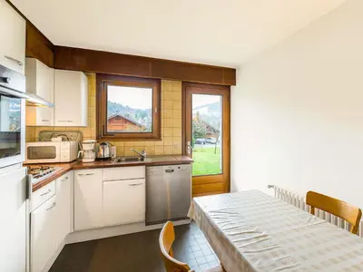 a kitchen with white cabinets and a table and a window at Appartement 2 pièces au rez-de-chaussée - Animaux admis - Près des pistes - FR-1-453-91 in Megève