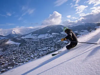 a man is skiing down a snow covered slope at Appartement confortable à Megève - Centre, 50m², 4 personnes, 3 balcons, TV et Wifi - FR-1-453-92 in Megève