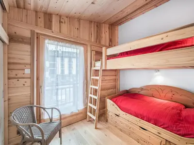a bedroom with bunk beds and a chair and a window at Charmant 3 pièces au centre de Megève, idéal 4 pers - FR-1-453-96 in Megève