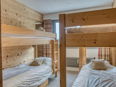 two bunk beds are in a room with wooden walls at Confortable Appartement 3 Chambres au Centre de Megève avec Wifi - FR-1-453-100 in Megève