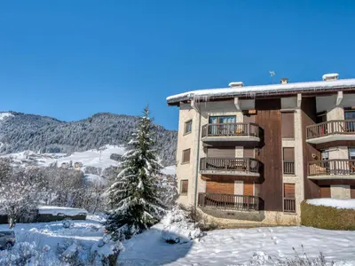 a building in the snow with a christmas tree at Appartement 2 Chambres Megève, Balcon Sud, Parking, Wifi - FR-1-453-101 in Megève