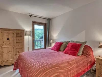 a bedroom with a bed with red pillows and a window at Appartement 2 Chambres Megève, Balcon Sud, Parking, Wifi - FR-1-453-101 in Megève