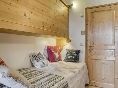 a bedroom with a bed with a wooden wall at Appartement 2 chambres en centre-ville à Megève avec balcon et wifi - FR-1-453-107 in Megève