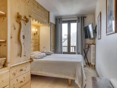 a bedroom with a bed and a tv in it at Appartement 2 chambres en centre-ville à Megève avec balcon et wifi - FR-1-453-107 in Megève