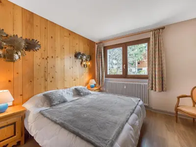a bedroom with a large bed and wooden walls at Appartement 2 pièces au cœur de Megève avec balcon et parking - FR-1-453-118 in Megève
