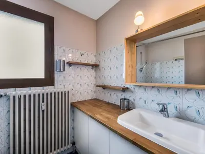 a bathroom with a sink and a mirror and a radiator at Appartement 2 pièces au cœur de Megève avec balcon et parking - FR-1-453-118 in Megève