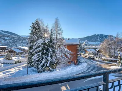 a snow covered street with a building and a tree at Appartement 2 pièces avec balcon et parking à Megève - FR-1-453-120 in Megève