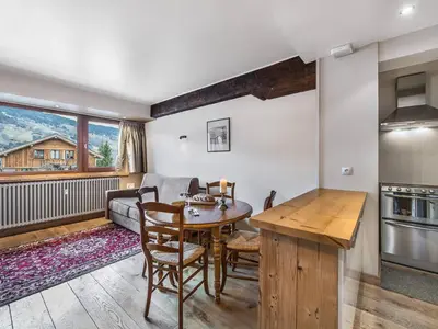 a kitchen and living room with a table and a couch at Charmant T2 au cœur de Megève pour 3 personnes - FR-1-453-106 in Megève