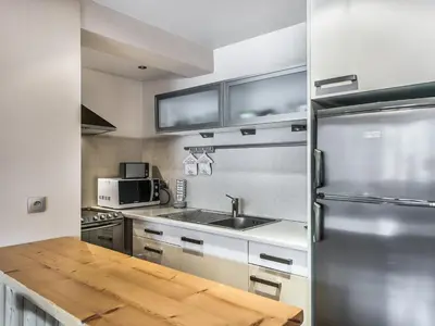 a kitchen with a stainless steel refrigerator and a wooden table at Charmant T2 au cœur de Megève pour 3 personnes - FR-1-453-106 in Megève