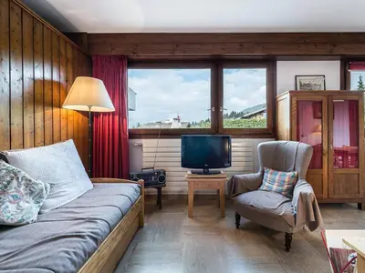 a living room with a bed and a tv and a chair at Studio à Megève Rochebrune, à 10 min du centre, pour 2 personnes - FR-1-453-124 in Megève