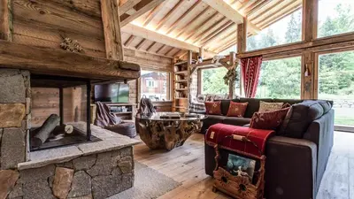 a living room with a stone fireplace in a house at Chalet Chal'heureux in Chamonix-Mont-Blanc