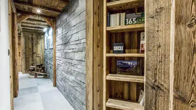 a room with wooden walls and shelves with books at Chalet Chal'heureux in Chamonix-Mont-Blanc
