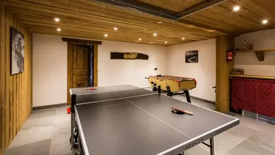 a ping pong table in the middle of a room at Chalet Chal'heureux in Chamonix-Mont-Blanc