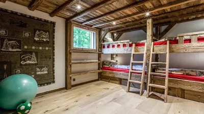 a room with three bunk beds and a large window at Chalet Chal'heureux in Chamonix-Mont-Blanc