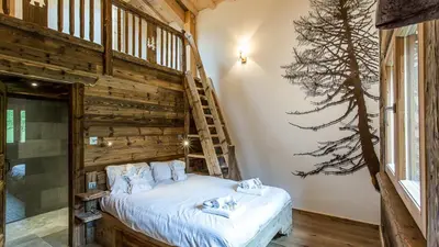 a bedroom with a bed with a wooden wall at Chalet Chal'heureux in Chamonix-Mont-Blanc
