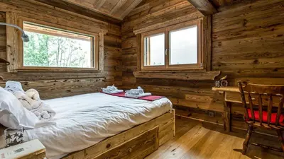 a bedroom with a bed in a log cabin at Chalet Chal'heureux + Annexe in Chamonix-Mont-Blanc