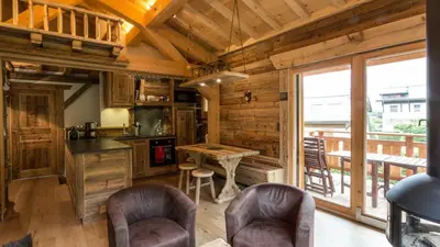 a kitchen with a table and chairs in a cabin at Chalet Chal'heureux + Annexe in Chamonix-Mont-Blanc