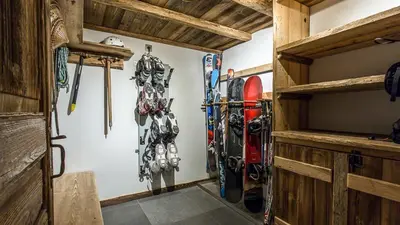 a room with skis and snowboards on the wall at Chalet Chal'heureux + Annexe in Chamonix-Mont-Blanc