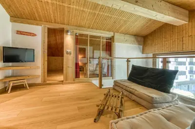 a living room with a couch and a tv at Brévent Loft Cozy 3-bedroom duplex 250m to Planpraz cable car in Chamonix-Mont-Blanc