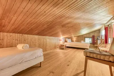 a bedroom with wooden walls and a wooden ceiling at Brévent Loft Cozy 3-bedroom duplex 250m to Planpraz cable car in Chamonix-Mont-Blanc