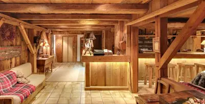 a large wooden building with snow on the ground at Residence Hôtelière La Renardiere in Samoëns