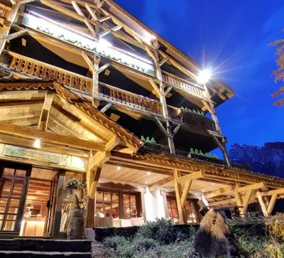 a large wooden building with a roof at Residence Hôtelière La Renardiere in Samoëns
