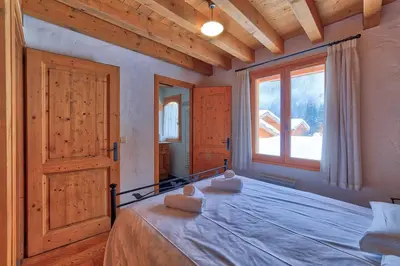 a bedroom with a bed and a large window at Chalet Coralie in Chamonix-Mont-Blanc
