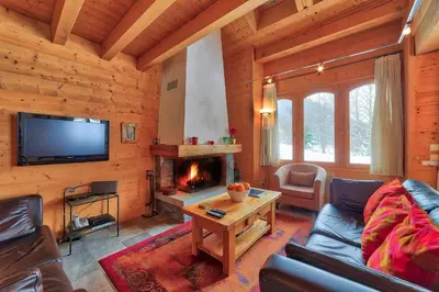 a living room with a fireplace in a log cabin at Chalet Coralie in Chamonix-Mont-Blanc