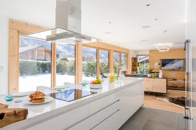 a kitchen with white cabinets and a large window at Chalet Montana- Chamonix All Year in Chamonix-Mont-Blanc